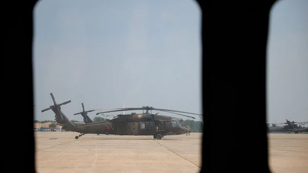 Un Black Hawk américain sur un tarmac en Irak, photographié à travers une fenêtre.