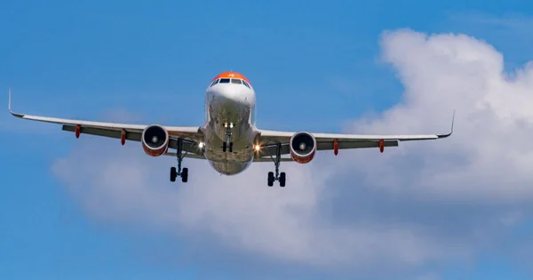 Un avion commercial en vol dans un ciel bleu nuageux.