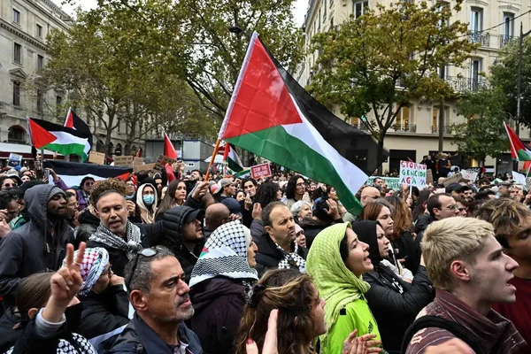 Des manifestants portant des drapeaux palestiniens rassemblés lors d'une manifestation de solidarité.