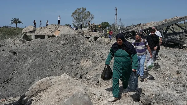 Une civile marchant à travers les ruines au Liban après les bombardements, dans le contexte de l'annonce d'une trêve par Donald Trump.