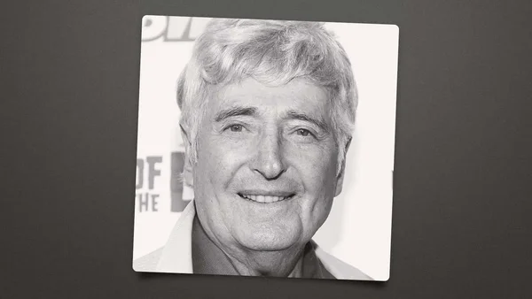 Une personne souriante en noir et blanc.