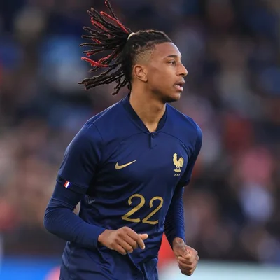 Michael Olise, portant le numéro 22, vu de profil sur le terrain.