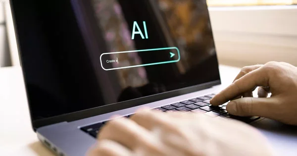 Une personne utilise un ordinateur portable avec une interface de recherche 'Create a' sur l'écran.