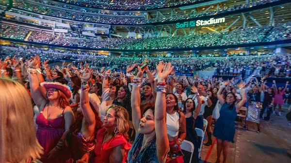 Spectateurs enthousiastes remplissant le SoFi Stadium lors d'un concert.