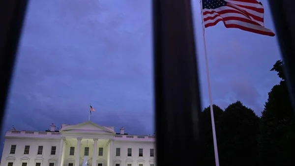 La Maison Blanche à la tombée de la nuit avec le drapeau américain.