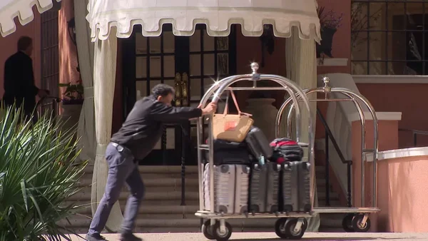 Un homme avec un chariot de bagages devant l'entrée d'un hôtel à Arlington.
