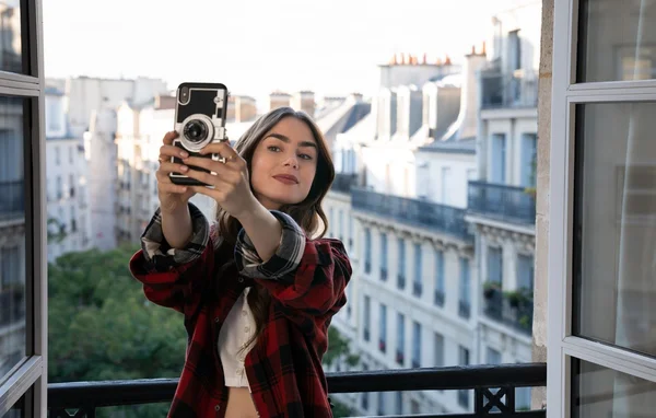 Scène montrant un personnage prenant un selfie avec une vue sur la ville.