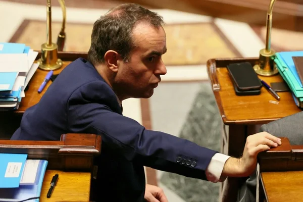 Sébastien Lecornu assis à son bureau de député dans l'hémicycle de l'Assemblée nationale.