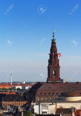 La tour ornée du Parlement danois à Copenhague avec sa flèche verte et des drapeaux nationaux