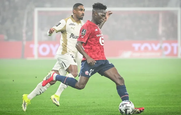 Action de jeu entre un joueur de Lens et un joueur de Lille sur la pelouse