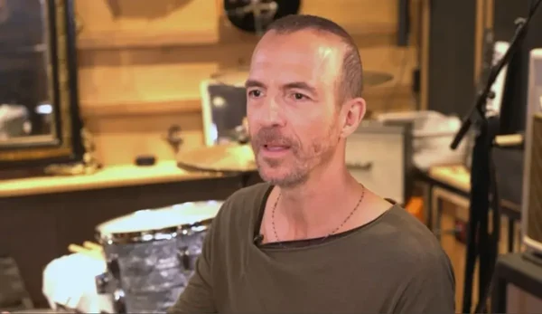 Calogero en studio de musique entouré d'instruments.