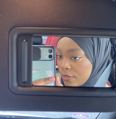 Azra Reed reflétée dans le rétroviseur d'une voiture