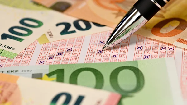 Un ticket de loto et des billets de banque en euros, rappelant un gain de millions récupéré après un oubli.