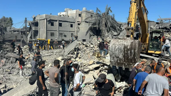 Des secouristes et des civils parmi les ruines après une frappe israélienne près d'un hôpital à Beyrouth.