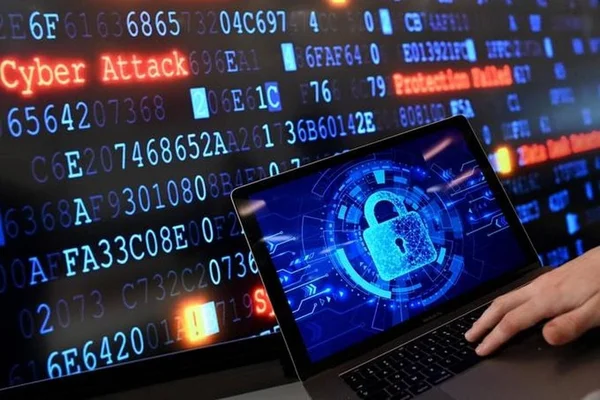 Un ordinateur portable affichant un cadenas numérique bleu sur fond de données avec la mention 'Cyber Attack' en rouge.