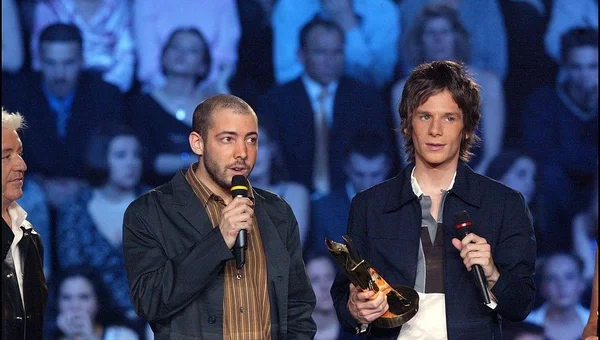 Le duo Modjo sur scène lors d'une remise de trophée, entouré d'un public dans une salle éclairée.