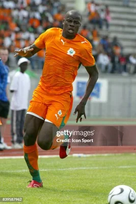 Emmanuel Eboué en pleine action sur le terrain, vêtu de sa tenue orange.