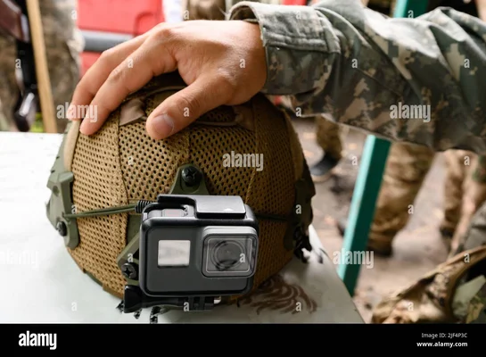 Casque tactique militaire beige avec caméra d'action montée, illustrant l'usage de GoPro dans un contexte de défense.