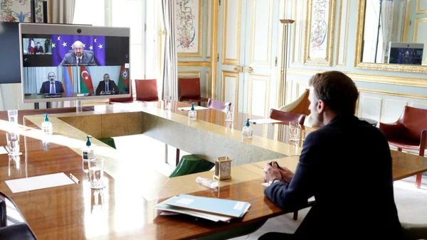 Entretien en visioconférence autour d’une table de conférence.