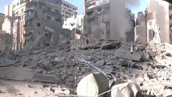 Un immeuble complètement détruit à Beyrouth, avec des gravats et de la poussière s'élevant du site.
