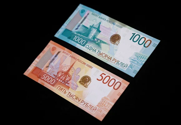 Billets de 1000 et 5000 roubles russes sur fond noir.