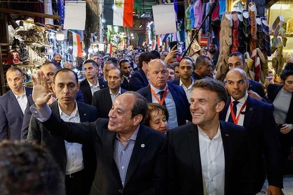 Emmanuel Macron et Abdel Fattah al-Sissi parcourant un marché lors de la visite présidentielle.