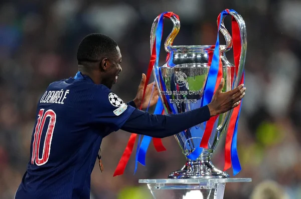 Ousmane Dembélé célèbre la victoire en Ligue des champions avec le trophée.
