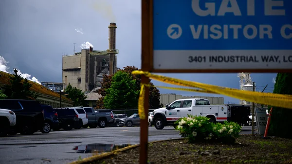 Scène sur le site de l'explosion chimique dans une usine de Washington, montrant la cheminée fumante et le ruban de sécurité jaune.