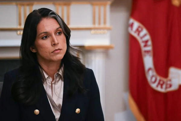 Tulsi Gabbard debout près d'un drapeau du Corps des Marines américain.