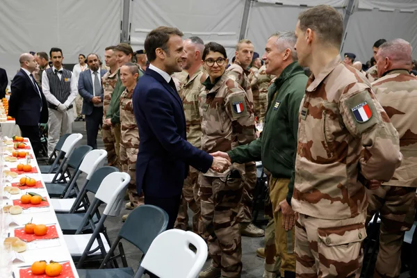 Rencontre officielle sous une tente avec des soldats français et des personnalités civiles au Moyen-Orient.
