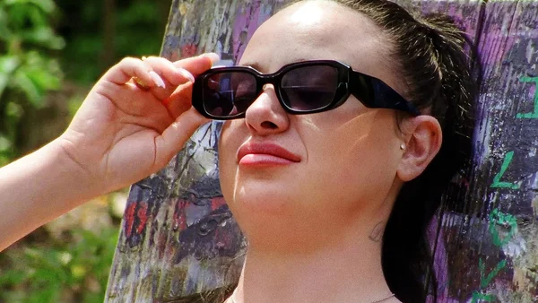 Eva Huault dans Shana, lunettes de soleil, regard déterminé.