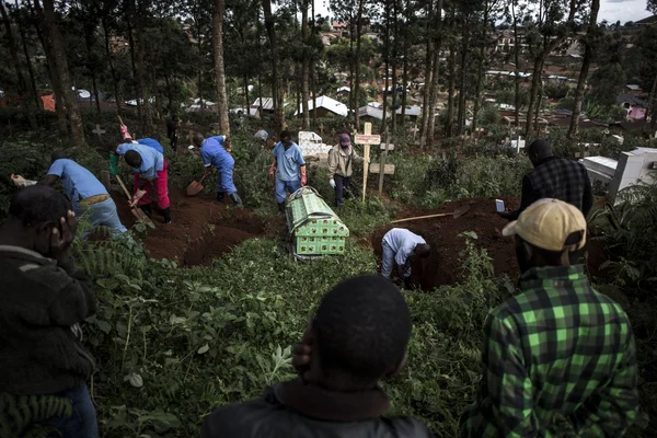 Des fossoyeurs et des agents de santé préparent l'inhumation d'une victime d'Ebola dans l'est de la RDC.