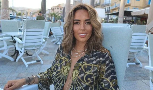 Hilona Gos attablée à une terrasse de café, chemise verte à motifs.