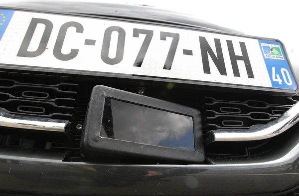 Plaque d'immatriculation et boîtier radar sur une voiture-radar privée.