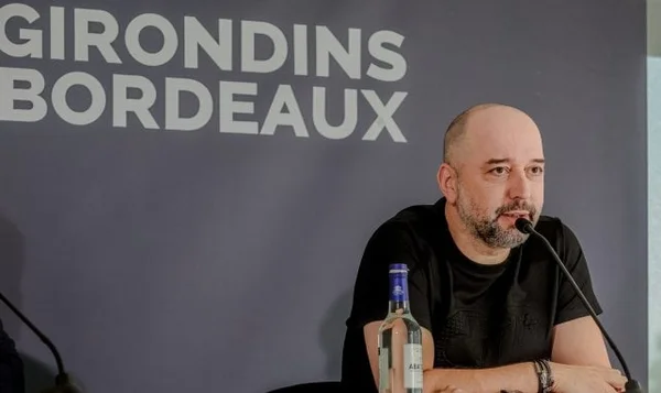 Gérard Lopez en conférence de presse, devant un fond aux couleurs des Girondins.