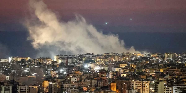 Panache de fumée s'élevant de bâtiments lors d'une frappe au Liban.