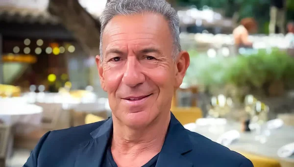 François Feldman lors d'une promotion chez Dooweet, souriant devant une terrasse de restaurant.