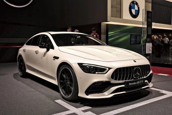 Mercedes-AMG GT 53 4 portes blanche en exposition lors d'un salon automobile.