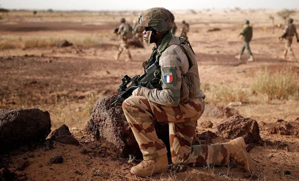 Soldat français lors d'exercices conjoints franco-marocains dans un paysage désertique.