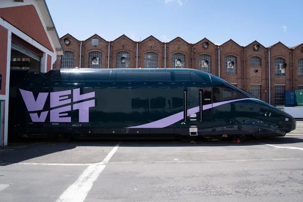 Le train Velvet, nouveau concurrent de la SNCF prévu pour 2028, devant un bâtiment industriel.