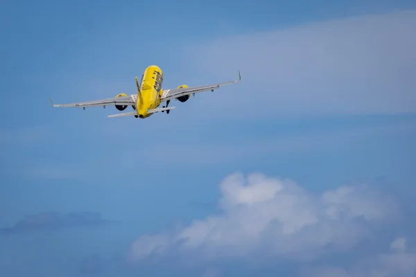 Un avion de Spirit Airlines en plein vol dans un ciel dégagé.