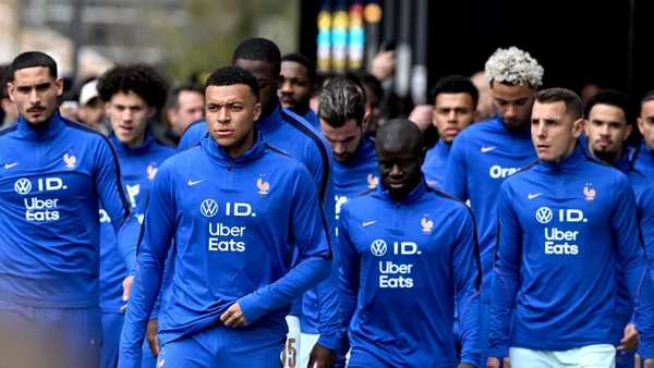 Joueurs de l'équipe de France en tenue officielle, marchant lors d'un déplacement.