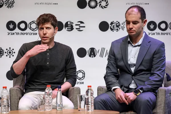 Deux hommes lors d'une conférence, l'un s'exprimant avec micro-casque.