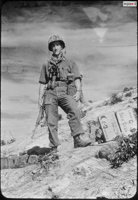 Soldat français du bataillon de Corée en position sur une colline rocheuse.