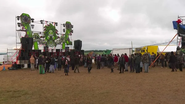 Foule de festivaliers devant la scène principale du Teknival de Bourges, sous un ciel couvert.