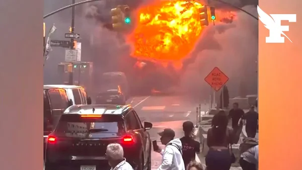 Explosion impressionnante d'une voiture dans le quartier de Wall Street, avec une boule de feu et une épaisse fumée s'élevant dans le ciel.