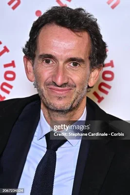 Portrait rapproché d'Alexandre Bompard, PDG de Carrefour, souriant légèrement.
