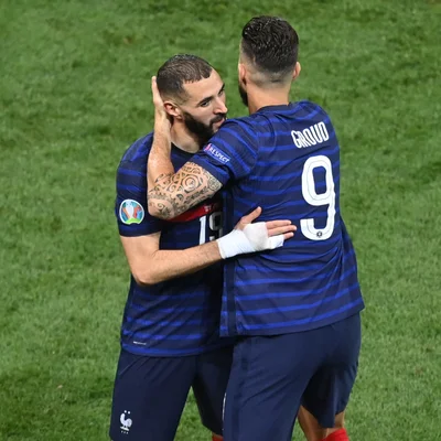 Olivier Giroud et un coéquipier s'enlacent après un match.
