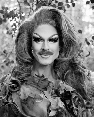 Pattie Gonia en noir et blanc, arborant un costume végétal et un maquillage théâtral, évoquant son message que la nature n'est pas binaire.