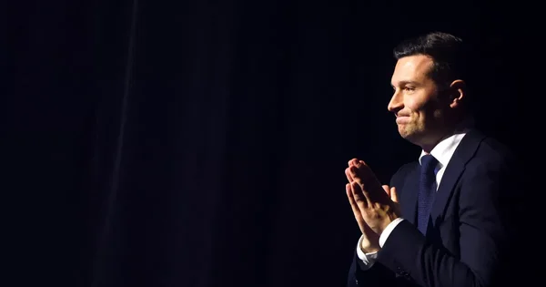 Jordan Bardella applaudissant lors d'un événement politique.